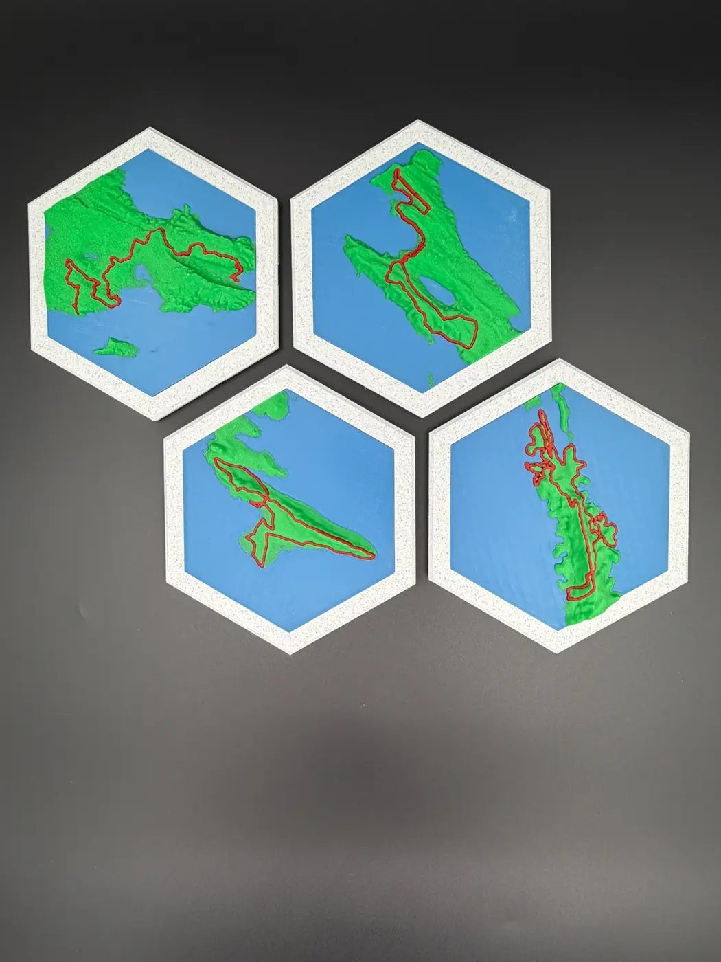 Four separate 4Islands relief map tiles ready to be arranged